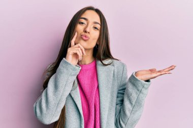 Genç İspanyol kız avuçlarını açmış, elinde bir şeyle kameraya bakıyor ve öpüşüyor. Güzel ve seksi. aşk ifadesi. 