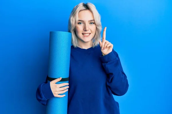 Ung Blond Flicka Håller Yogamatta Leende Med Idé Eller Fråga — Stockfoto