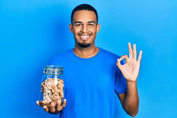 Joven Afroamericano Hombre Sosteniendo Tarro Galletas Chips Chocolate Haciendo Signo — Foto de Stock