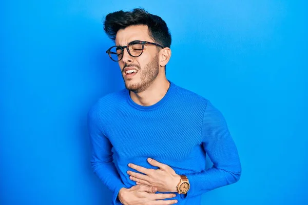 Mladý Hispánec Nosí Ležérní Oblečení Brýle Rukou Břiše Protože Dělá — Stock fotografie