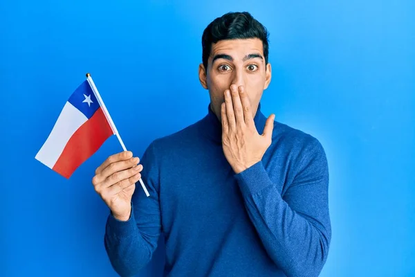 Pohledný Hispánský Obchodník Držící Chile Vlajku Ústech Rukou Šokovaný Vystrašený — Stock fotografie