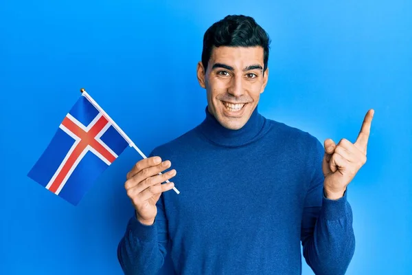 Snygg Latinamerikansk Man Håller Flagga Ler Glad Pekar Med Hand — Stockfoto