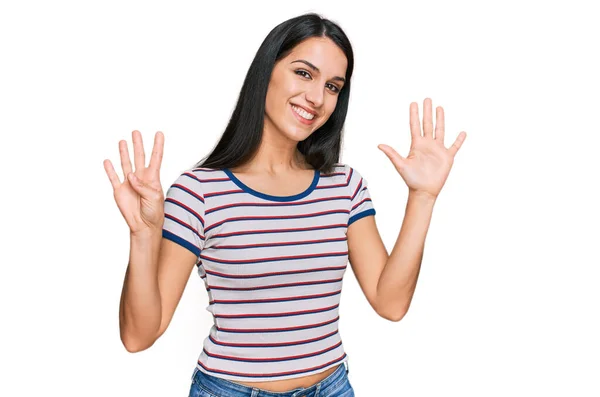 若いですヒスパニック女の子身に着けていますカジュアルストライプTシャツ表示し 指番号9で指摘します — ストック写真