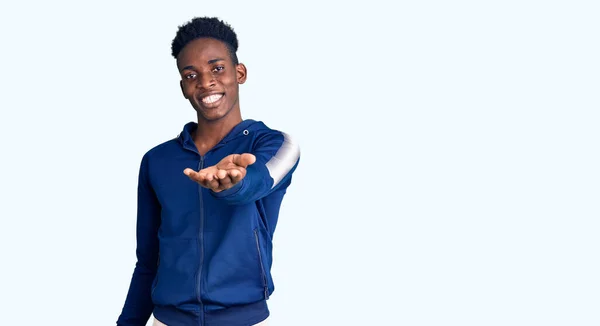 Jovem Afro Americano Vestindo Roupas Esportivas Sorrindo Alegre Oferecendo Palma — Fotografia de Stock