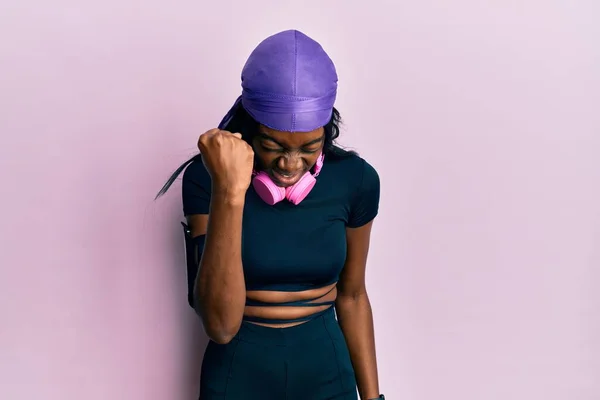 Young African American Woman Wearing Gym Clothes Using Headphones Angry — Stockfoto