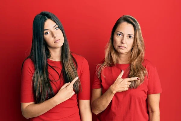 Família Hispânica Mãe Filha Vestindo Roupas Casuais Sobre Fundo Vermelho — Fotografia de Stock