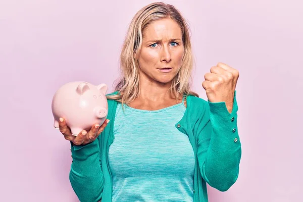Middle Age Caucasian Blonde Woman Holding Piggy Bank Annoyed Frustrated — ストック写真
