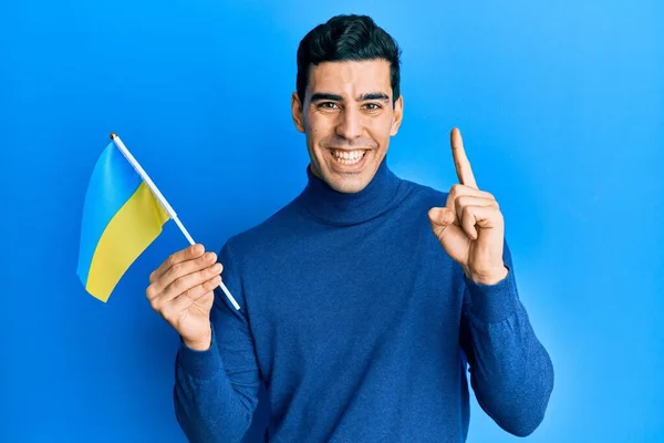 Snygg Hispanic Man Bär Ukrainsk Flagga Leende Med Idé Eller — Stockfoto