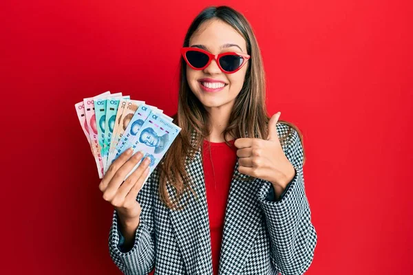 Jovem Morena Segurando Yuan Notas Chinesas Sorrindo Feliz Positivo Polegar — Fotografia de Stock