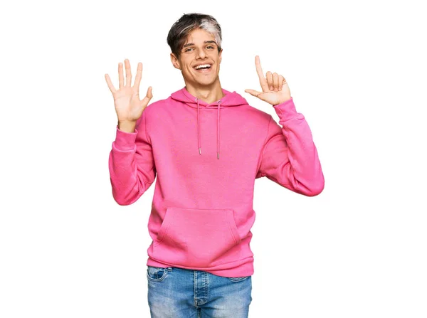 Junger Hispanischer Mann Trägt Lässiges Rosafarbenes Sweatshirt Und Zeigt Mit — Stockfoto