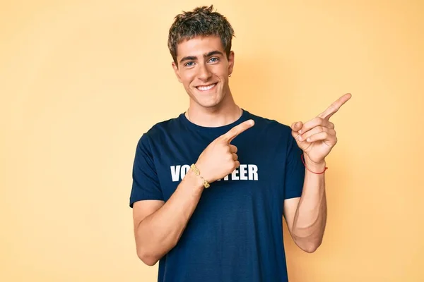 Νεαρός Όμορφος Άντρας Που Φοράει Εθελοντική Μπλούζα Χαμογελώντας Και Κοιτάζοντας — Φωτογραφία Αρχείου