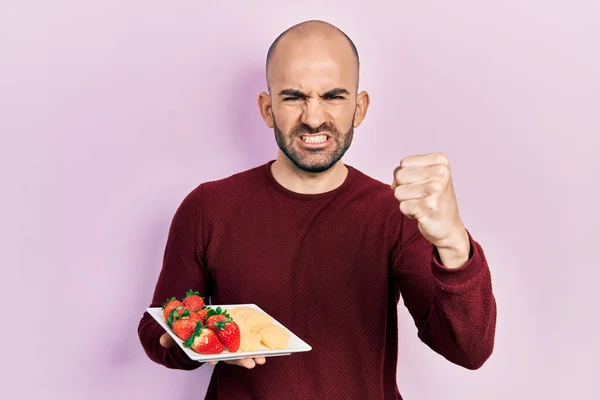 Young Bald Man Eating Fresh Healthy Fruits Annoyed Frustrated Shouting — Stock Photo, Image