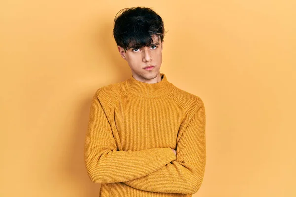 カジュアルな黄色のセーターを着てハンサムなヒップスターの若い男懐疑的で緊張し 両腕を組んで顔に不承認式 否定的な人 — ストック写真