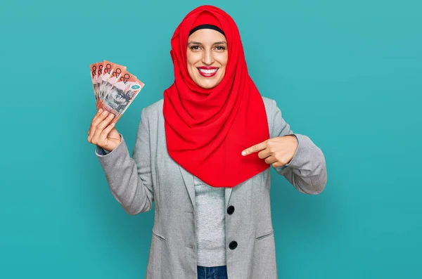 Όμορφη Ισπανίδα Που Φοράει Ισλαμική Μαντίλα Κρατώντας Αυστραλιανά Χαρτονομίσματα Δείχνοντας — Φωτογραφία Αρχείου