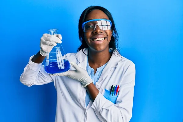 若いですアフリカ系アメリカ人女性身に着けています科学者制服保持テストチューブ見て正と幸せな立ちと笑顔で自信を持って笑顔示す歯 — ストック写真
