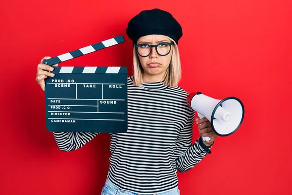 Hermosa Mujer Rubia Sosteniendo Video Película Clapboard Megáfono Deprimido Preocuparse —  Fotos de Stock