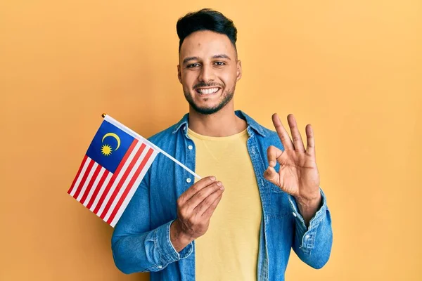 Молодой Араб Флагом Малайзии Делает Хорошо Знак Пальцами Улыбаясь Дружелюбный — стоковое фото