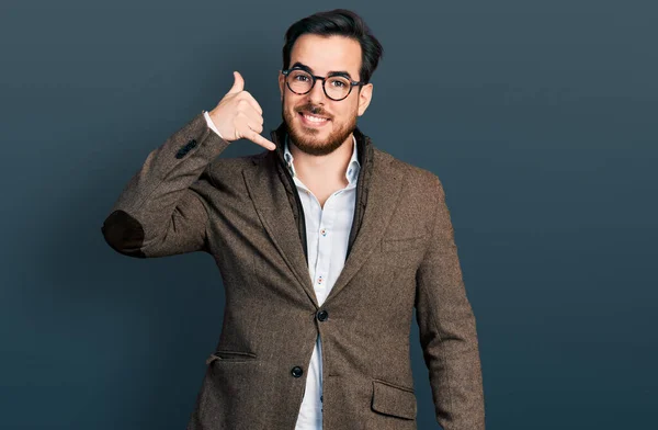 ビジネスジャケットを着た若いヒスパニック系の男性と眼鏡を手や指で電話で話をするような携帯電話のジェスチャーを行う笑顔 コミュニケーションの概念 — ストック写真