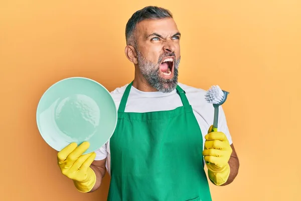 Homem Bonito Meia Idade Usando Avental Segurando Scourer Lavar Pratos — Fotografia de Stock