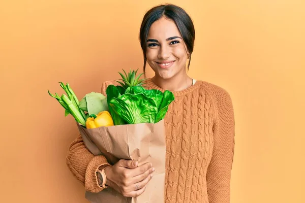 Joven Morena Sosteniendo Bolsa Papel Con Pan Comestibles Luciendo Positiva —  Fotos de Stock