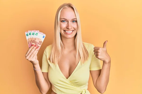 Menina Loira Jovem Segurando Notas Euro Sorrindo Feliz Positivo Polegar — Fotografia de Stock