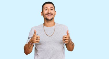 90 'ların tarzında başarı işareti takan yakışıklı bir adam. Elleriyle olumlu jest yapıyor. Gülümsüyor ve mutlu. Neşeli ifade ve kazanan jest. 