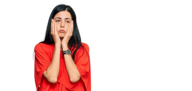 Güzel, genç bir kadın. Günlük kıyafetler giyiyor. Yorgun eller. Yüzü, depresyonu ve üzüntüyü örtüyor. 