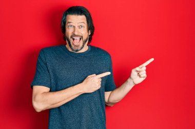 Orta yaşlı beyaz bir adam parmaklarını kenarı işaret ederek çılgınlığı kutluyor ve hayret içinde haykırarak başarıyı haykırıyor.. 