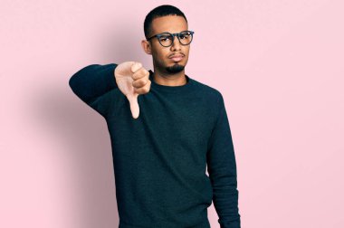Genç, Afro-Amerikan bir adam günlük kıyafetler ve gözlük takıyor mutsuz ve kızgın görünüyor reddediliyor ve olumsuz jestler yapıyor. kötü ifade. 