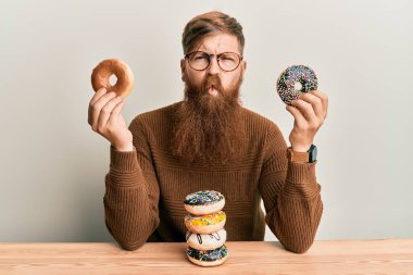 Genç İrlandalı kızıl adam kahvaltıda çörek yiyor. Ağızlı balık suratı yapıyor ve şaşı bakıyor. Deli ve komik.. 