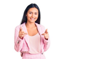 İş kıyafetleri içinde genç ve güzel bir Latin kız kamerayı mutlu ve komik bir suratla işaret ediyor. iyi enerji ve titreşimler. 
