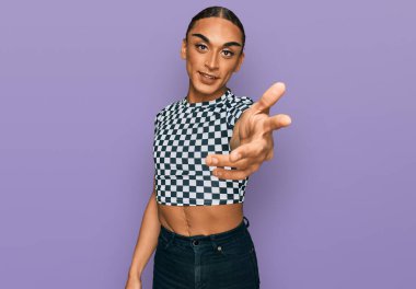 Makyaj yapan, uzun saçlı, modern kıyafetler giyen, gülümseyen, dostça el sıkışan İspanyol transseksüel bir adam. başarılı iş. 