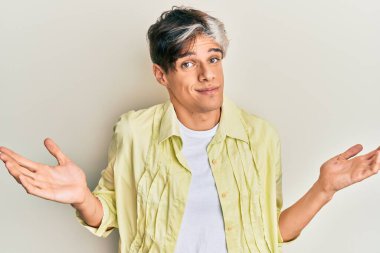 Gündelik kıyafetler giyen genç İspanyol adam habersiz ve kolları açık, hiçbir fikri ve şüpheli bir yüzü var.. 