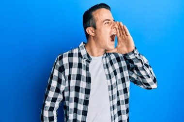 Yakışıklı genç adam gündelik tişört giyip el ele tutuşarak bağırıyor ve çığlık atıyordu. iletişim konsepti. 