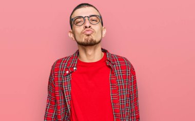 Latin asıllı genç adam, sıradan kıyafetler giyip kameraya bakıyor. Canlı yayında öpücük yolluyor. Güzel ve seksi. aşk ifadesi. 