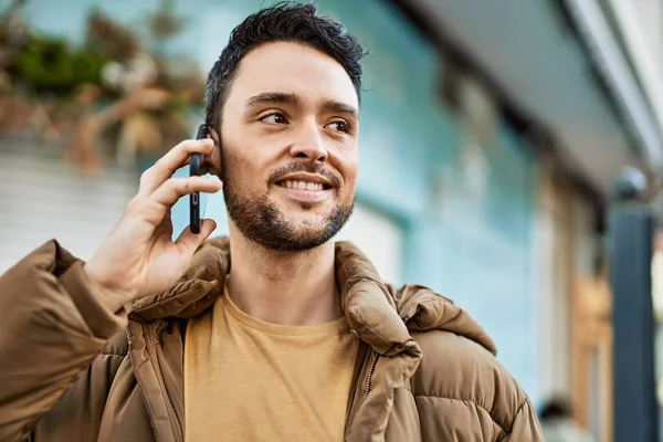 Ung Latinamerikansk Man Ler Glad Talar Smartphone Staden — Stockfoto