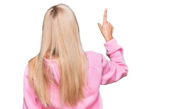 Młoda Blondynka Ubrana Luźną Bluzę Pozująca Tyłem Przodu Palcem — Zdjęcie stockowe