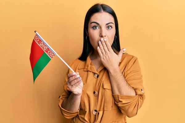 Jovem Morena Segurando Bandeira Belarus Cobrindo Boca Com Mão Chocada — Fotografia de Stock