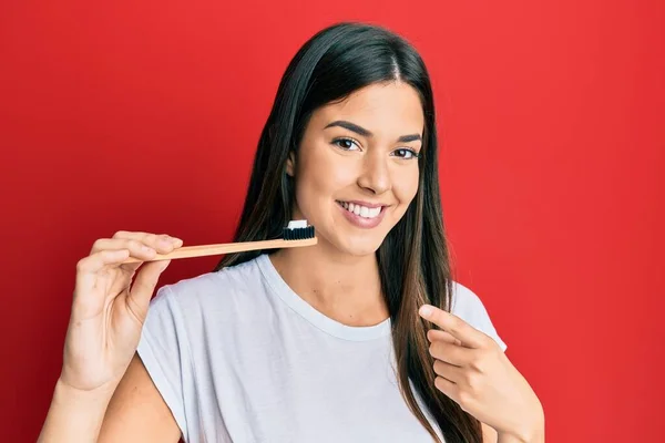 Young Brunette Woman Holding Toothbrush Toothpaste Smiling Happy Pointing Hand — Stock Photo, Image