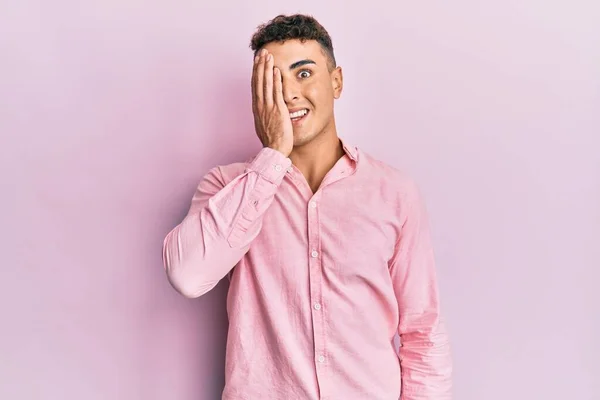 Hispánský Mladý Muž Neformálním Oblečení Zakrývajícím Jedno Oko Rukou Sebevědomý — Stock fotografie