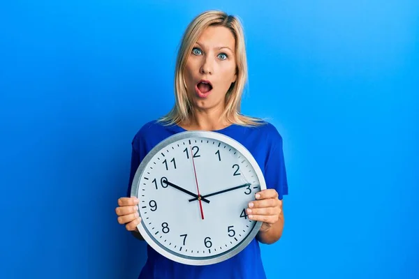 Beautiful Middle Age Blonde Woman Holding Big Clock Shock Face — 스톡 사진