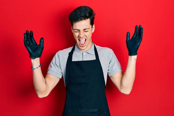 Young Hispanic Man Wearing Apron Celebrating Mad Crazy Success Arms — Stock Photo, Image