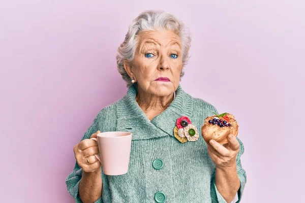 Mulher Cabelos Grisalhos Sênior Bebendo Uma Xícara Café Comendo Bun — Fotografia de Stock