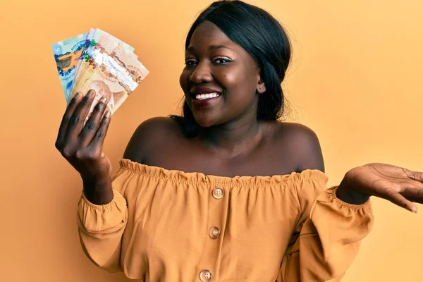 Αφρικανή Νεαρή Γυναίκα Που Κρατάει Καναδικά Δολάρια Γιορτάζει Επίτευγμα Χαρούμενο — Φωτογραφία Αρχείου