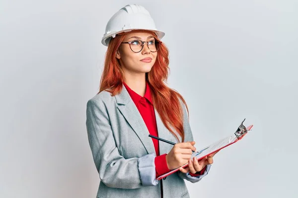 Jonge Roodharige Vrouw Draagt Architect Hardhoed Glimlachen Naar Zijkant Staren — Stockfoto