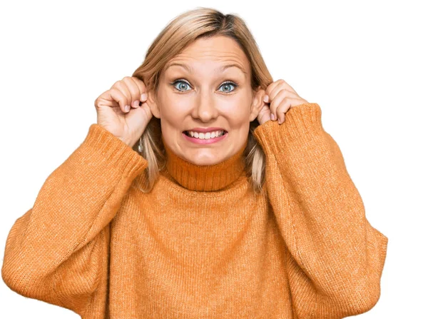 中世の白人女性は カジュアルな冬のセーターを着て指で耳を引く笑みを浮かべて 面白いジェスチャー オーディション問題 — ストック写真