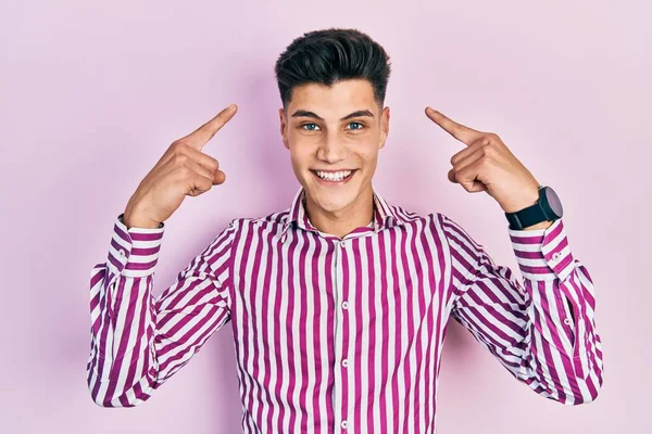 Молодий Іспаномовний Чоловік Повсякденному Одязі Посміхається Вказуючи Голову Пальцем Рук — стокове фото