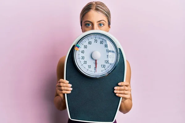 Schöne Blonde Frau Hält Gewichtsmaschine Gewichtsverlust Entspannt Mit Ernstem Gesichtsausdruck — Stockfoto