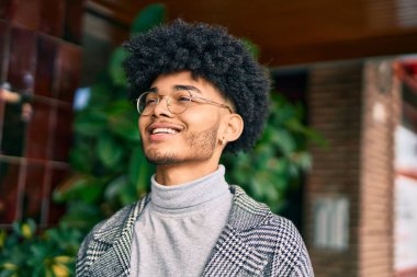 Genç Afrikalı Amerikalı iş adamı şehirde mutlu mesut dikiliyor..