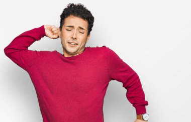 Genç, yakışıklı, rahat, rahat, rahat, rahat ve sabahları esneyen, gündelik kıyafetler giyen bir adam. 